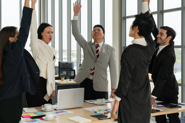 multiethnic business team including caucasian and asian people celebrate success of new project in office. diversity of workplace concept