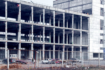 The frame of a multi-storey building on a city building. Construction of a new house, new building
