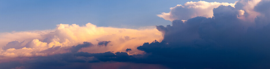 Panorama of the evening sky with dark and light sunlit sky. The sky at sunset