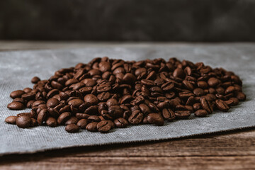 Roasted coffee beans on canvas, wooden table