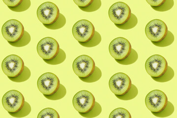 Modern pattern with kiwi slices on a green background illuminated by bright summer sunlight - Pop art design minimal creative concept - Top view and flat lay