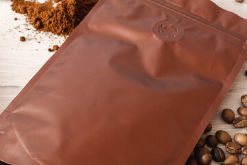 Blank coffee packaging with coffee seeds, ground coffee, coffee packaging mockup with empty space to display your branding design.