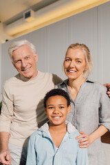 Obraz premium Grandparents with their multiracial son standing at the kitchen while cooking