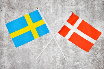 Hand flags of Sweden and Danmark on Abstract background