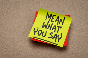 Mean what you say advice or reminder, handwriting on a sticky note, communication and personal...