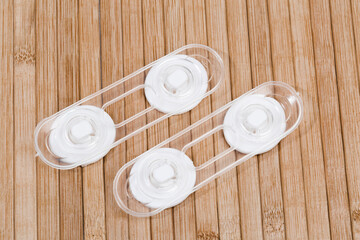 Child safety furniture door lock on wooden background .