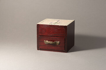 Brown wooden box with drawer with gold decoration handle on jewellery.
