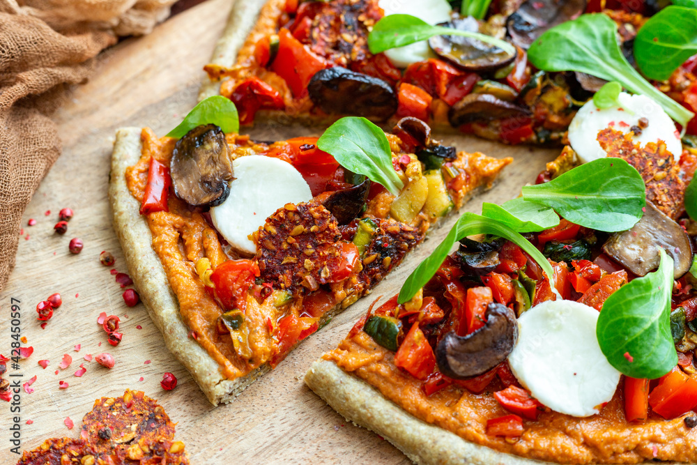 Wall mural closeup shot of raw vegan fresh pizza with mushrooms and other vegetables served on a wooden board