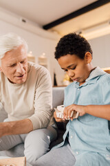 Man and his son considering wooden model of the airplane while playing