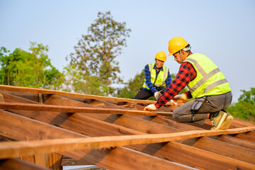 Two carpenters are working at the construction site. Construction of the wooden roof structure. Ideas for renovating and extending wooden houses.