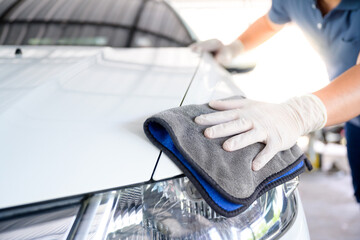 Car wash service personnel clean their cars with microfiber cloths. Details and valet concept...