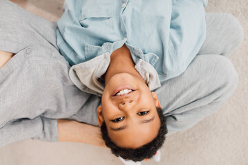 Boy laying at the knees of his grandmother and smiling to the camera