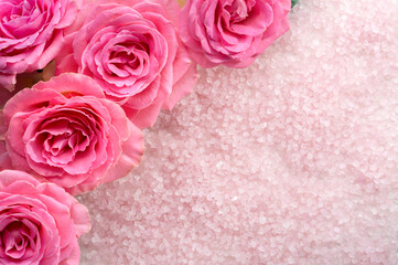Spa salt crystals and  pink roses.  Flat lay.