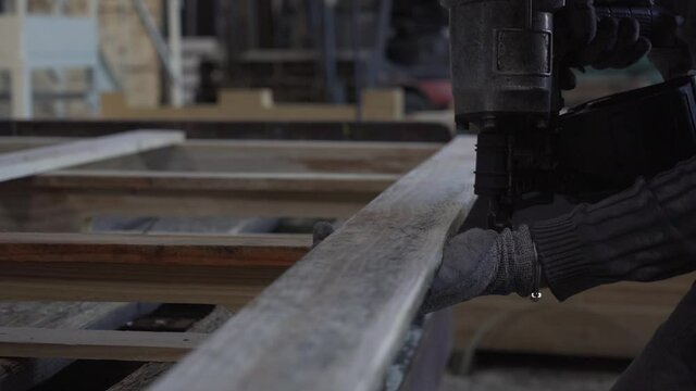 arisant travaillant le bois avec cloueuse pneumatique