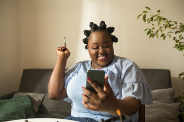 Woman preparing makeup and smiling at camera while shooting the video tutorial