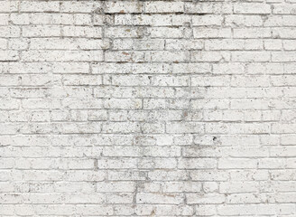 The texture of the old brick wall painted in white. Vintage brick background with cracked paint.