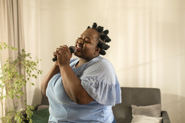 Woman holding microphone and singing a song at home