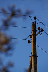 old pillar with wires on the blue evening sky background.