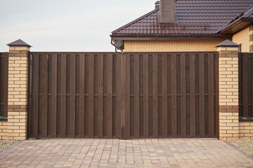 Brown wooden gate and fence in a private house.