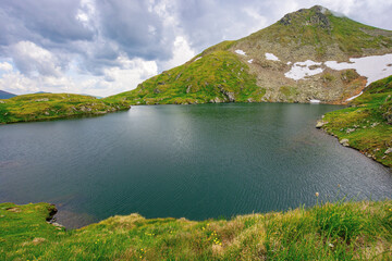 summer scenery with lake on high altitude. beautiful landscape of fagaras mountain ridge in summer. open view in to the distant peak beneath a fluffy clouds
