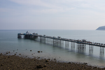 Llandudno pier in summer. North Wales tourist destination. Old victorian pier at low tide