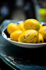 bolw of cajá mango brazilian fruit , Spondias dulcis ,black background, ripe fruit, exotic plant,  Spondias cythera, ripe fruit, yellow tropical fruits, fresh cajá fruits in a bowl, exotic fruits