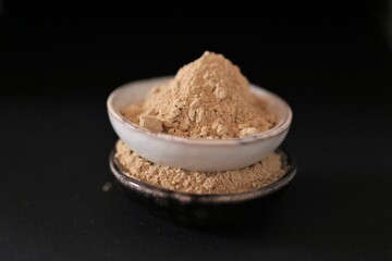 Maca  powder in ceramic cups on black background. Peruvian ginseng.peruvian Maca powder close-up. Super food. Natural energetic. Healthy natural products.  Lepidium meyenii