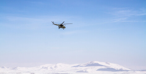 Fototapeta na wymiar helicopter flies against the blue sky