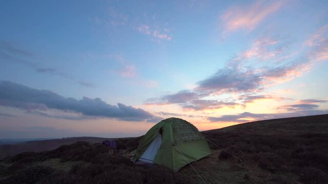 A wild camping tent at sunset in the wilderness