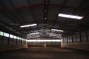 Photo of an empty indoor riding hall for horses and riders