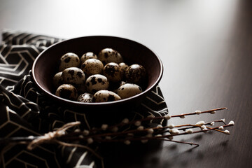 Quail eggs in a clay plate on a dark background