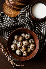 Quail eggs in a clay plate on a dark background