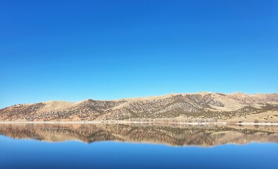 beautiful landscape of hills reflection at Echo Reservoir with stunning beautiful clear sky as background in Utah, USA
