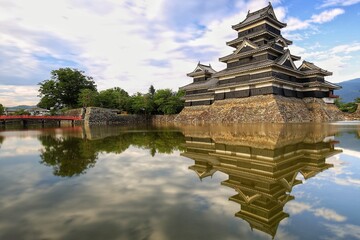 beautiful landscape view of Matsumoto Castle with reflection in the pond of Matsumoto public park