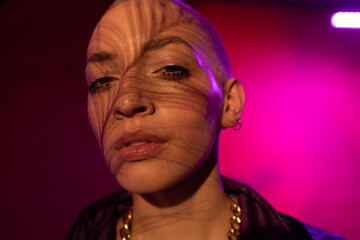 Woman with shadow of the peacock leather at her face looking at the camera