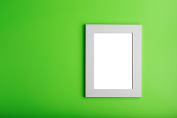 White photo frame on green background with free space.