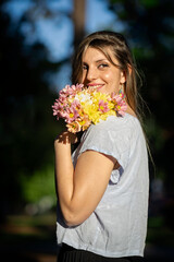Naklejka premium Young blonde woman with happy expression holding a bouquet of flowers
