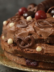 Birthday chocolate cake decorated with chocolates and cherries