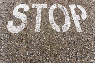 STOP a large inscription on the asphalt in full screen