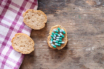 Fototapeta na wymiar Slices of bread with pills on wooden table