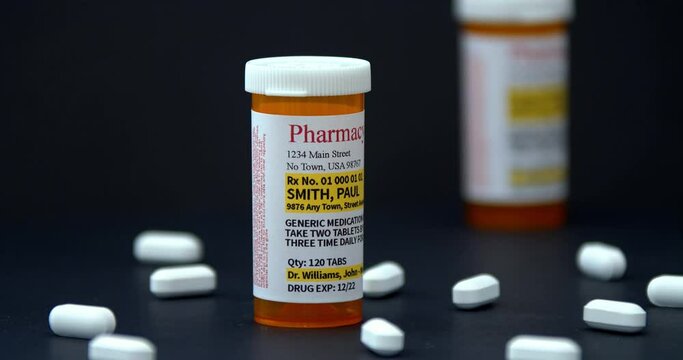 A Camara going around A Non-Proprietary Generic Medication Prescription with medicine pills on a black background