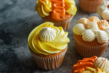 Delicious muffins. Orange and lemon cream muffins. Cupcakes on a concrete table 