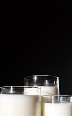 Copy space of three glasses of milk on a black background