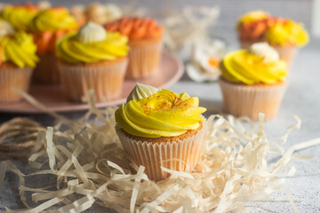 Delicious muffins. Orange and lemon cream muffins. Cupcakes on a concrete table 