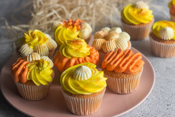 Delicious muffins. Orange and lemon cream muffins. Cupcakes on a concrete table 