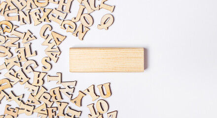 On a light background, wooden letters and a wooden block with a place to insert text. Template. Copy space