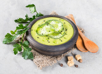 Vegan soup puree green radish with parsley, croutons in a wooden bowl on a light gray background in rustic style