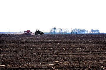 Fototapeta premium tractor with seeder in the field in early spring