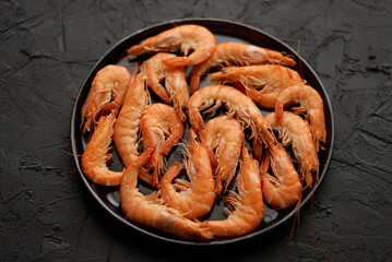 Boiled big sea prawns or shrimps placed on black ceramic plate