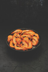Boiled big sea prawns or shrimps placed on black ceramic plate